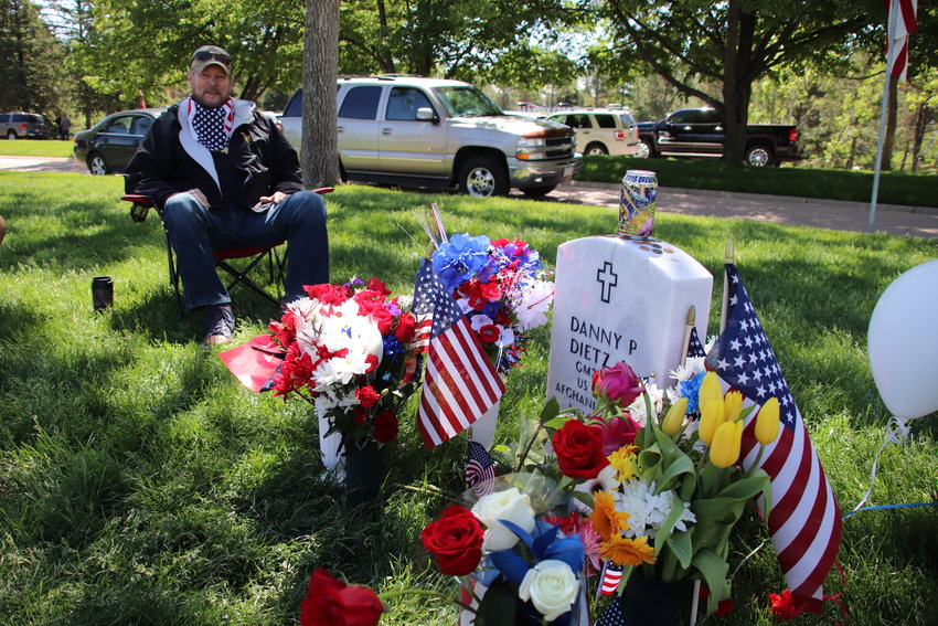 Danny Dietz Sr. sits beside his son's grave at Fort Logan National Cemetery. Dietz Jr., a Navy SEAL, was killed in Afghanistan in 2005.